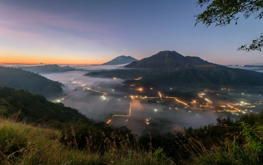 Mist over the Pinggan highland valley in Kintamani at dawn, the cool microclimate where Bali arabica cherries ripen slowly